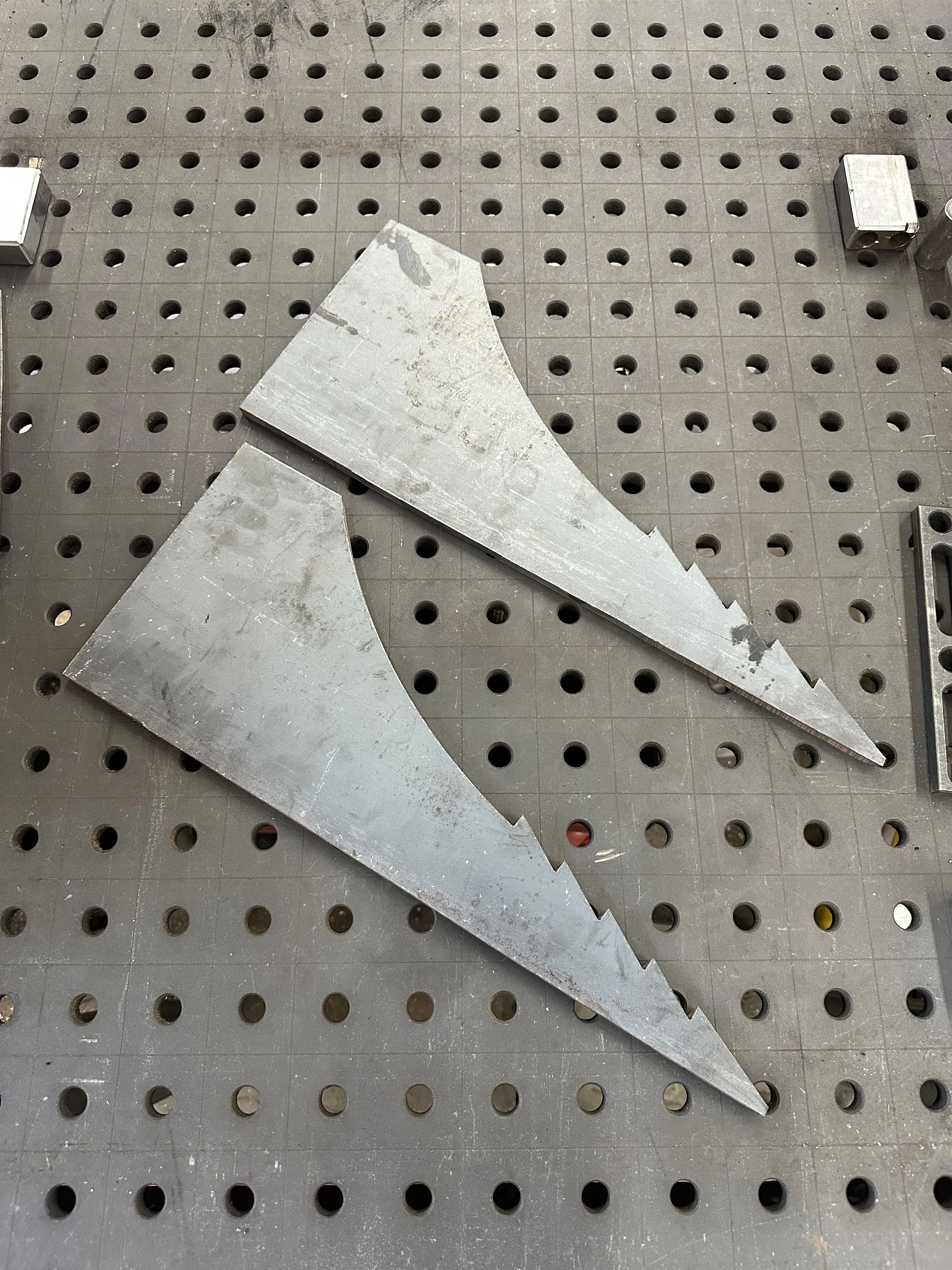 CNC-cut steel parts on a fabrication table